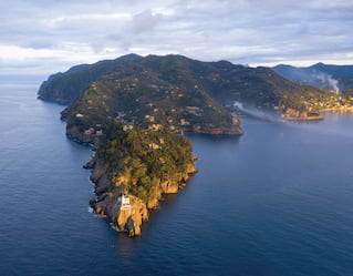 Barca in avvicinamento alla costa rocciosa vicino Portofino