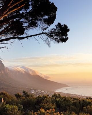 Table mountain range rolling down towards the sea at sunset