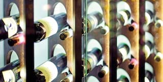 Rows of wine bottles behind a contemporary glass wine case