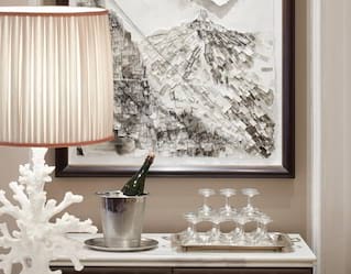 Champagne in a cooler next to a pyramid of coupe glasses