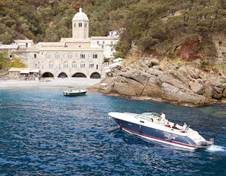 Boat approaching a rocky bay near Portofino